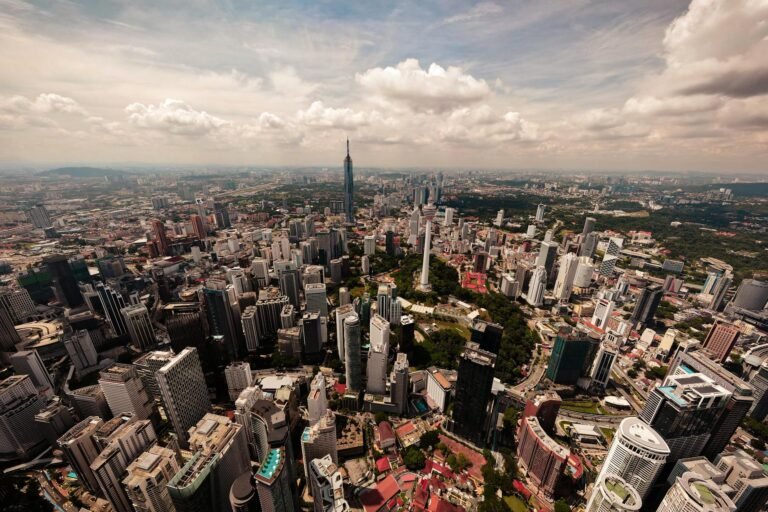 Stunning aerial view of Kuala Lumpur's cityscape featuring iconic skyscrapers and lush greenery.