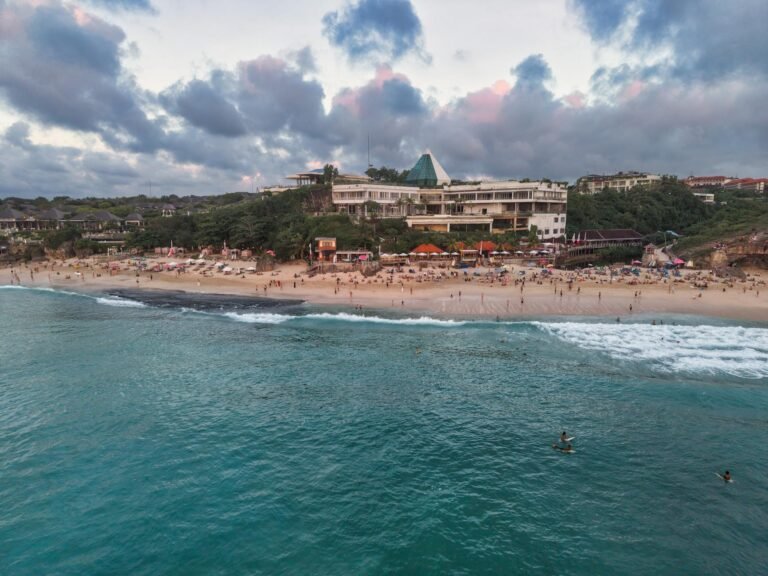 Scenic aerial view of a beachfront resort in Bali, Indonesia at sunset.
