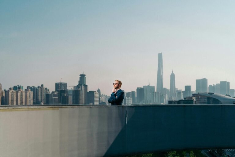 A man stands on a rooftop, gazing over Shanghai's iconic skyline and skyscrapers.