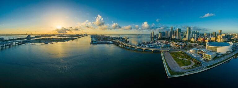 Aerial view of the Miami skyline with sunrise reflecting on the ocean.