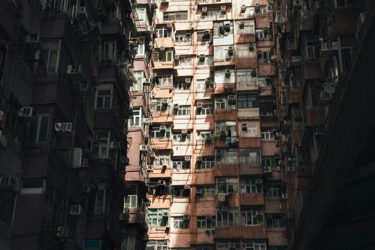 Detailed view of a densely packed urban apartment building with striking sunlight and shadows.
