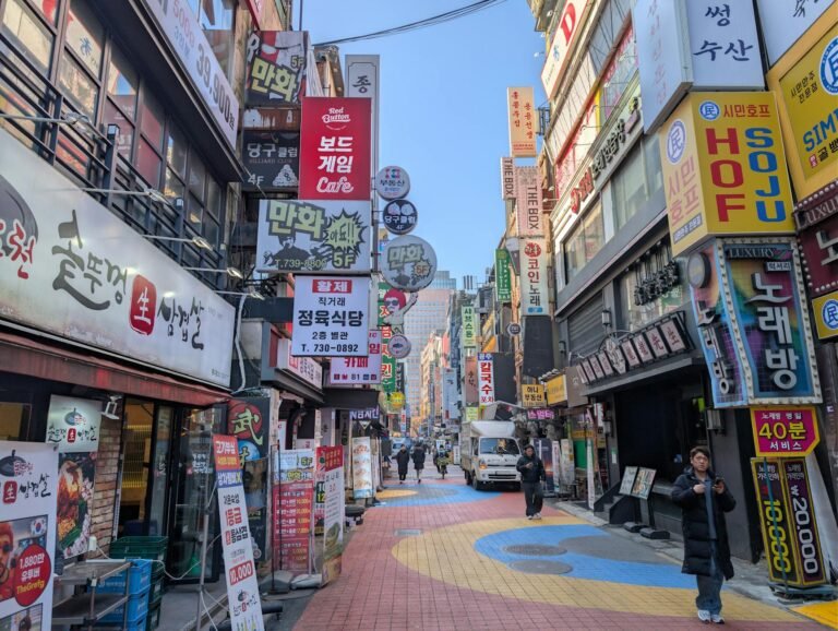 Colorful street filled with signs and people in Seoul's bustling district.
