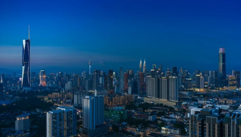 Discover the vibrant Kuala Lumpur skyline featuring iconic landmarks in the evening glow.