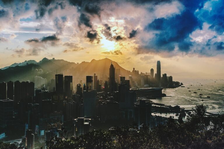 Dramatic sunset over the skyline of Hong Kong Island with vibrant colors and sea view.