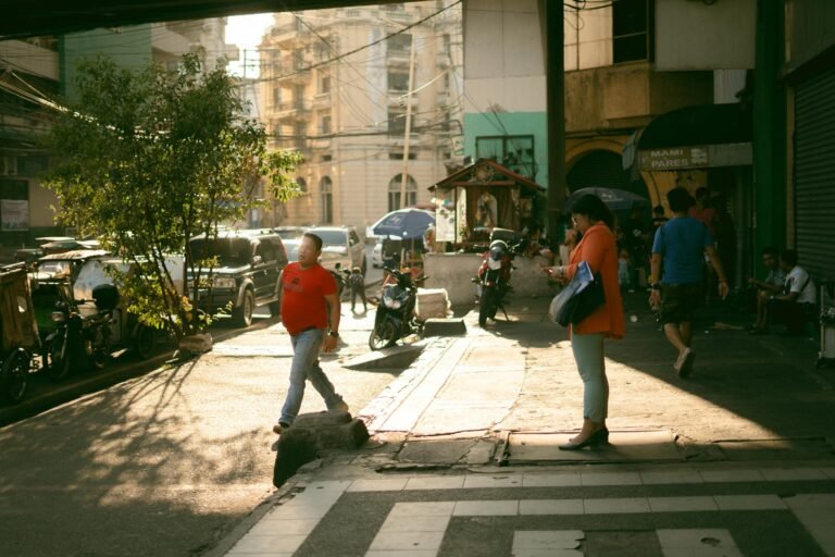 A bustling street in Maynila, showcasing daily urban life with people and vehicles in action.