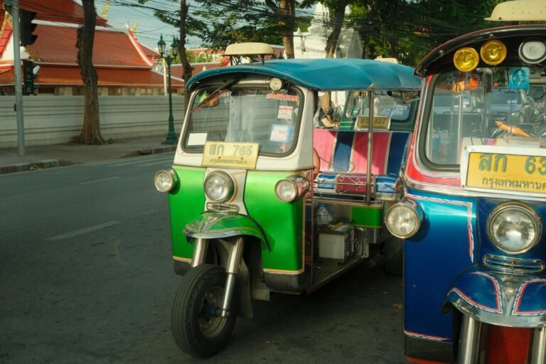 Colorful auto rickshaws line a bustling street in Bangkok, capturing urban transportation.