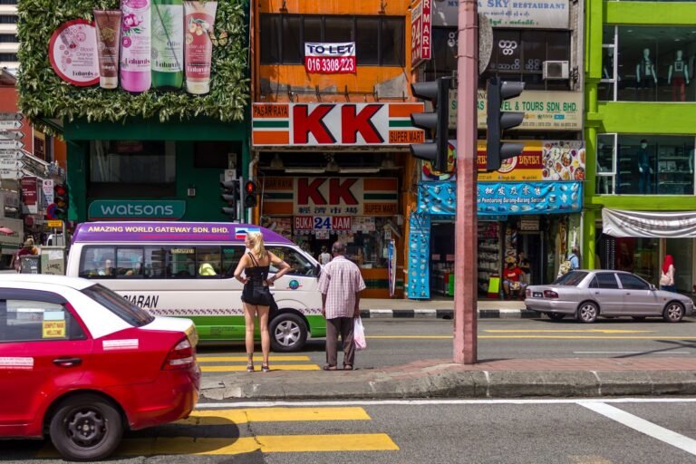 Bustling street with people and traffic in Kuala Lumpur, Malaysia.