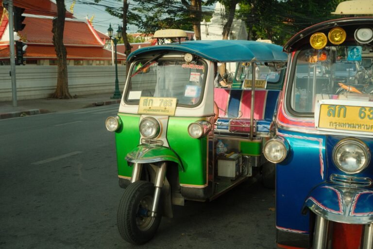 Colorful auto rickshaws line a bustling street in Bangkok, capturing urban transportation.
