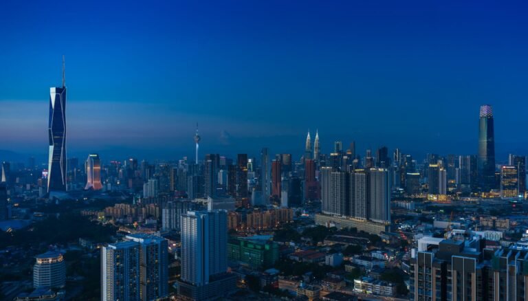 Discover the vibrant Kuala Lumpur skyline featuring iconic landmarks in the evening glow.