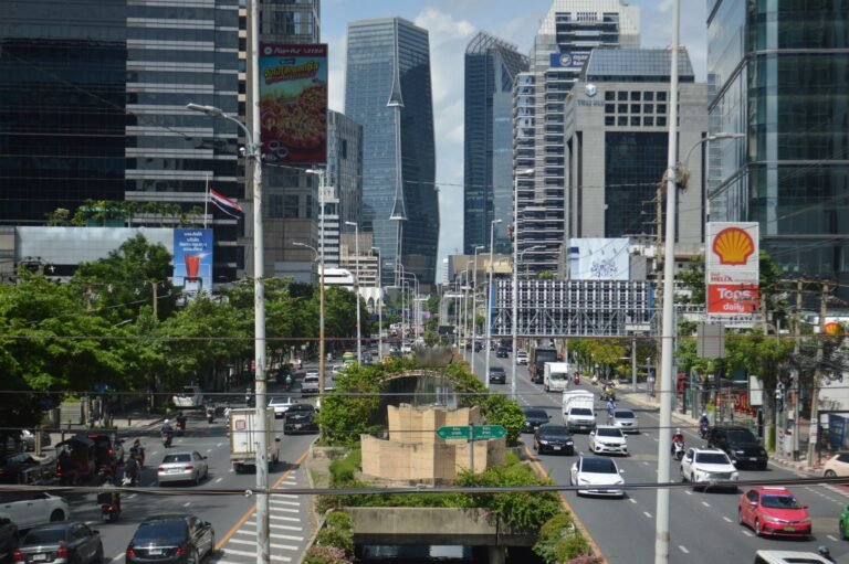 A vibrant view of Bangkok's bustling business district with modern skyscrapers and heavy traffic.