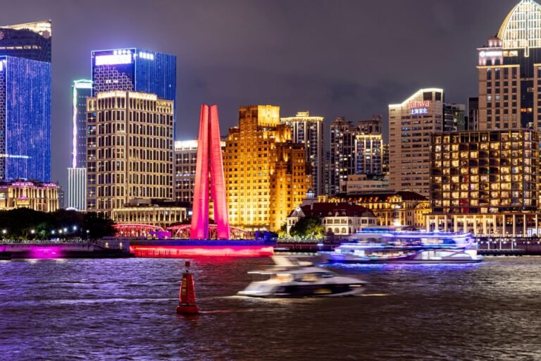 Vibrant night view of Shanghai's illuminated skyline and bustling waterfront.