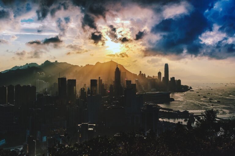 Dramatic sunset over the skyline of Hong Kong Island with vibrant colors and sea view.